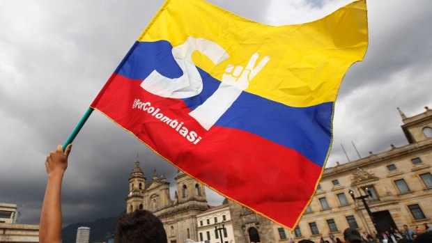 A supporter of the peace deal waves a flag during a rally in front of Congress, in Bogota, Colombia, on Monday.