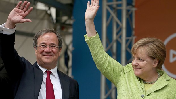 German Chancellor Angela Merkel, right, and North Rhine-Westphalia top candidate of her Christian Democrats, Armin Laschet, wave to supporters on Saturday.