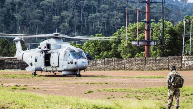 A British helicopter lands on a football pitch in Freetown, Sierra Leone to deliver supplies to medical teams.