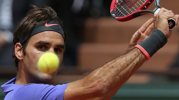 Eyes on the ball: Roger Federer prepares to play a backhand during his clash with Gael Monfils at the French Open.