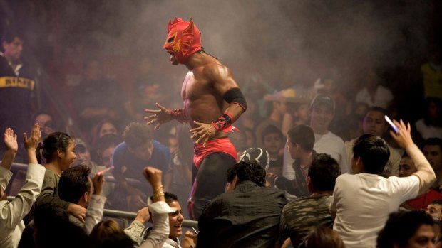 A lucha libre wrestler shouts to the crowd at Arena Mexico.
