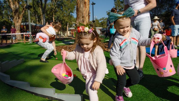 Kids scramble to collect as many eggs as they can in the Easter egg hunt.