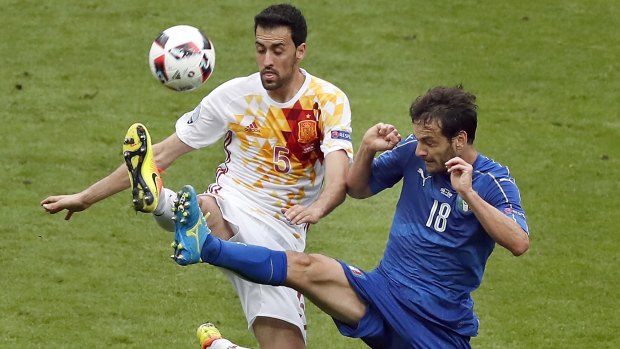 Spain's Sergio Busquets and Italy's Marco Parolo challenge for the ball.