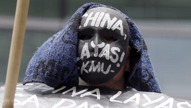 A protester wears a mask during a rally at the Chinese Consulate at the financial district of Makati city, east of Manila.
