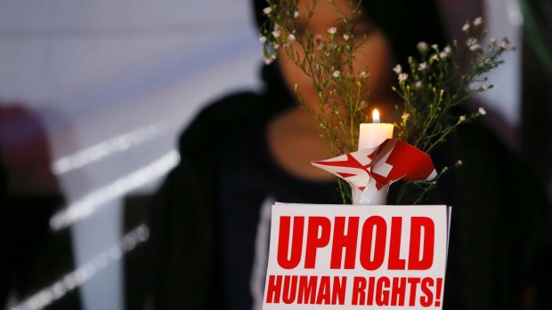 A human rights activist holds a candle for the victims of extra-judicial killings around the Philippines.