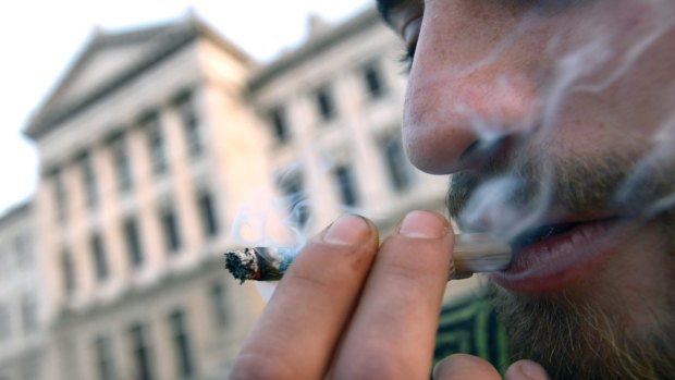 A man smokes marijuana outside Uruguayan Congress during a debate to legalize marijuana and regulate production and distribution.