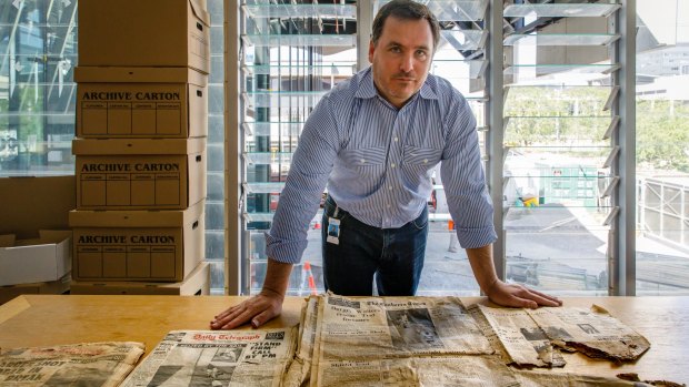 Contract manager Sean Egan with an old copy of The Canberra Times found during excavations for the courts building project.