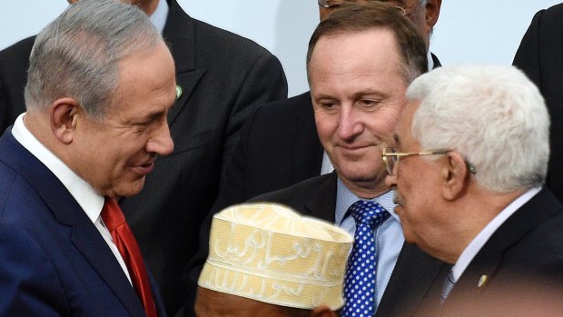 Israeli Prime Minister Benjamin Netanyahu, left, talks with Palestinian President Mahmoud Abbas, right, as NZ PM John Key watches, in Paris last year.