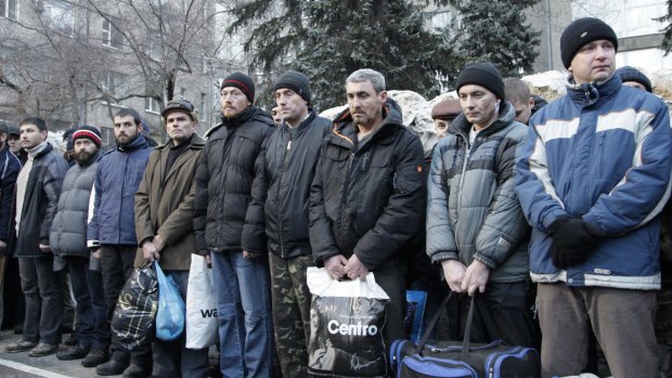 Ukrainians prepare for an exchange of prisoners in front of a prison in Donetsk.