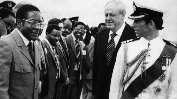 Prince Charles, right, talks with Robert Mugabe while British Governor Christopher Soames and the Rhodesian cabinet look on in 1980, in Salisbury, (now Harare) Rhodesia (now Zimbabwe).