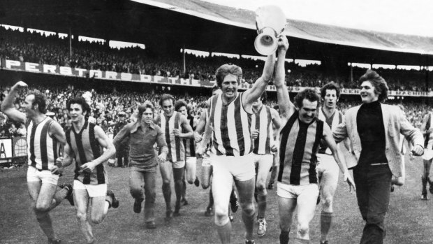 North Melbourne run around the oval with the premiership cup after the 1975 grand final.