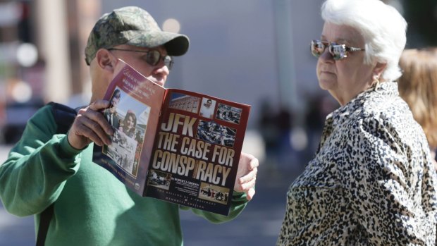A newsagent shows a passerby a magazine in Dealey Plaza Dallas, on Wednesday.
