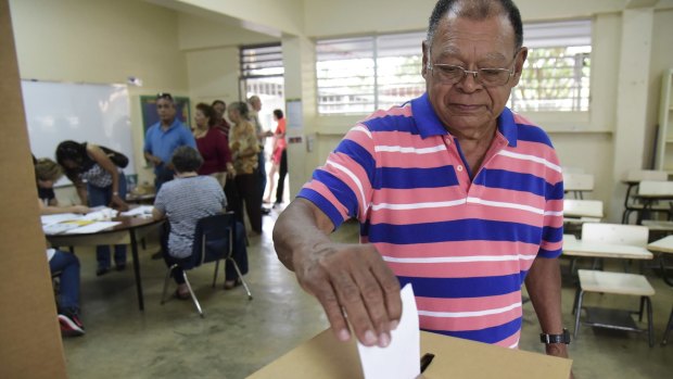 Puerto Rico resident Hector Alvarez casts his ballot during the US territory's Democratic primary election.