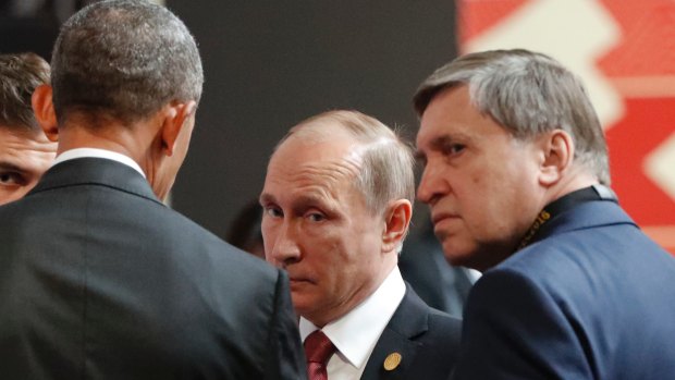 US President Barack Obama, left, talks with Russia's President Vladimir Putin, centre, and Kremlin foreign affairs adviser Yuri Ushakov in Lima, Peru, on Sunday.