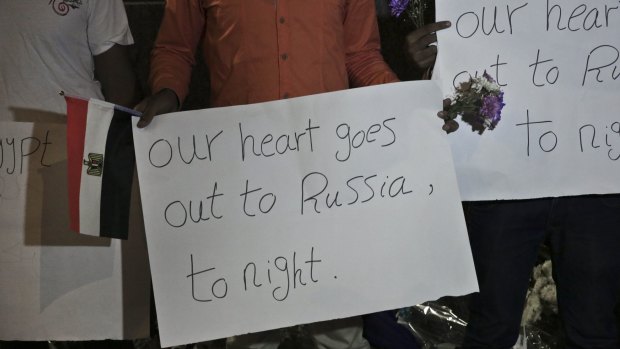 Members from the Egyptian Youth Movement hold signs during a gathering to commemorate the plane crash victims outside the Russian embassy in Cairo, on Sunday.
