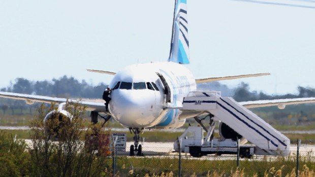 A man leaves the hijacked aircraft of Egyptair from the pilot's window.