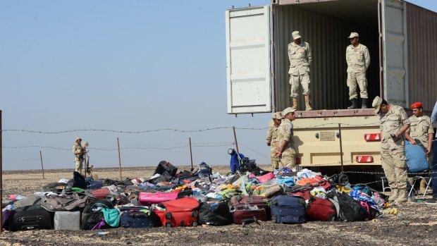 Egyptian soldiers collect personal items belonging to the victims of the Russian plane that crashed on Egypt's Sinai Peninsula.