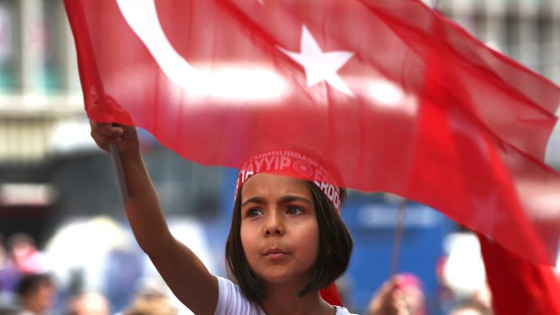 A Turkish girl wears a headband bearing the name of President Recep Tayyip Erdogan during a demonstration in Ankara in July. Children in their early teens are known to have been married in religious ceremonies in Turkey.