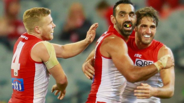 Swans Josh Kennedy and Daniel Hannebery congratulate Adam Goodes after he kicked a goal at the MCG on Saturday night.