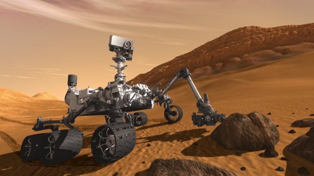 In this 2011 artist's rendering provided by NASA/JPL-Caltech, the Mars science laboratory Curiosity examines a rock on Mars.