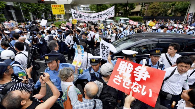Police officers try to control protesters outside a public hearing on the security legislation in Yokohama, south of Tokyo, on Wednesday.