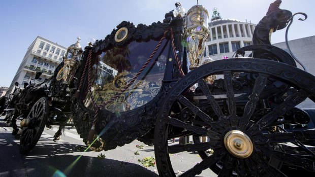 A horse-drawn carriage containing the coffin of purported Mafia boss Vittorio Casamonica is driven past the Don Bosco church during the funeral ceremony in Rome.