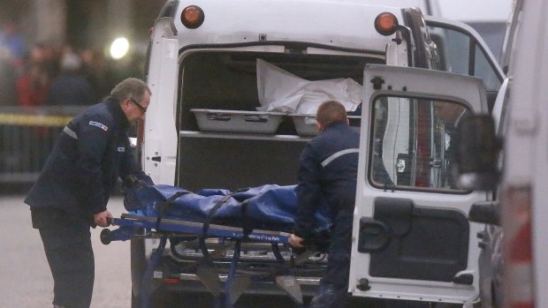 Two men carry a body into a hearse after the raid in Saint-Denis on Wednesday.