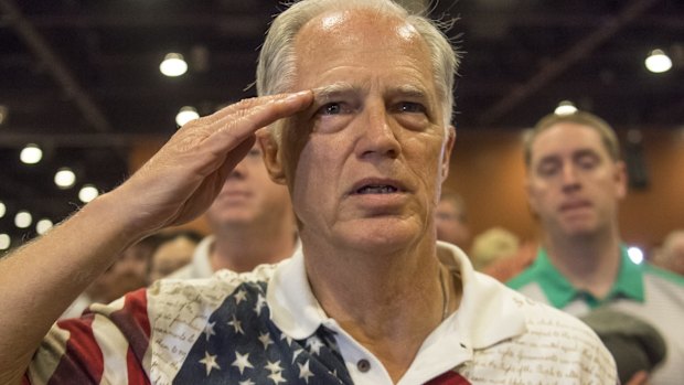 An attendee salutes as the pledge of allegiance is recited at a or Donald Trump event.