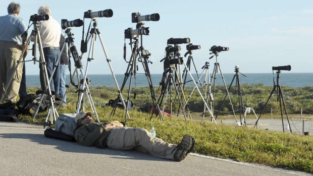 Rest up: A news photographer awaits the launch of The Delta IV Heavy rocket with the Orion spacecraft from Cape Canaveral.