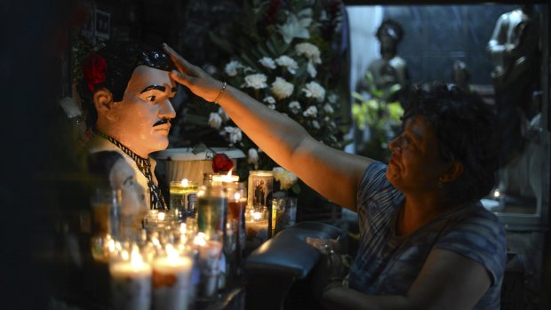 A woman prays to folk-saint Jesus Malverde, to heal her sick daughter in Culiacan, Mexico. Jesus Malverde is worshipped by many drug traffickers in this region  known as the cradle of drug trafficking in the country and home to escaped drug lord Joaquin "El Chapo" Guzman.