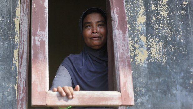 An ethnic Rohingya woman weeps as she looks out from a temporary shelter for migrants whose boats washed ashore in Lapang, Aceh province, Indonesia.