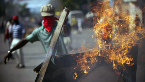Protesters block a street with burning tyres in Port-au-Prince as they called for the resignation of the prime minister Laurent Lamothe.