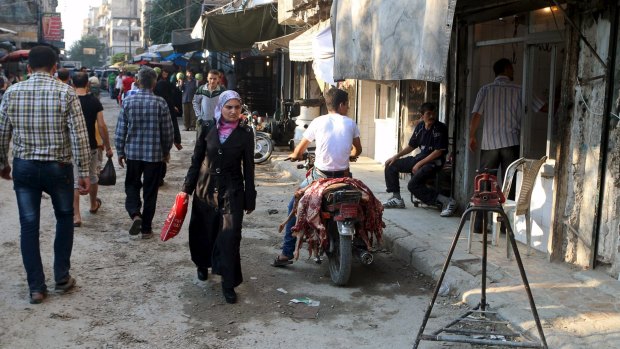 A man carrying meat on his motorcycle rides at a market Aleppo, Syria, on the last week of the holy month of Ramadan.