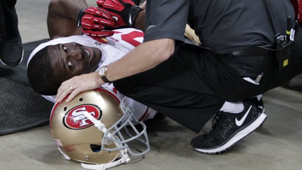 Reggie Bush is attended to by a trainer after he slipped on concrete during the 49ers' loss to the St Louis Rams.