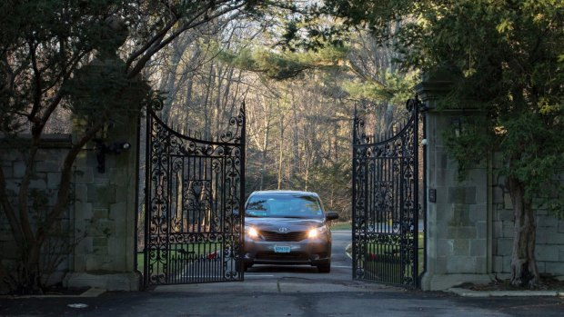 Cars with diplomatic plates drive out of a compound near Glen Cove on Long Island on Friday after the US expelled dozens of Russian diplomats.