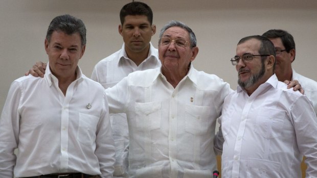 Cuban President Raul Castro, centre, embraces Colombian President Juan Manuel Santos, left, and FARC commander Timoleon Jimenez.