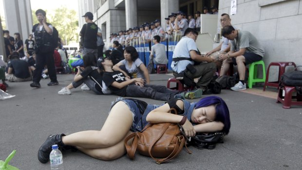 A student sleeps on the ground during a protest at the entrance to the Ministry of Education in Taipei on Friday.