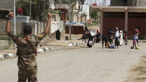 An Iraqi soldier asks displaced people to raise their hands as he checks for suicide bombers during fighting in Hit, Iraq, on Wednesday. 