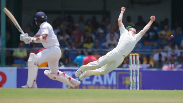 Edged: Mitchell Marsh flings himself at a shot from Dinesh Chandimal.