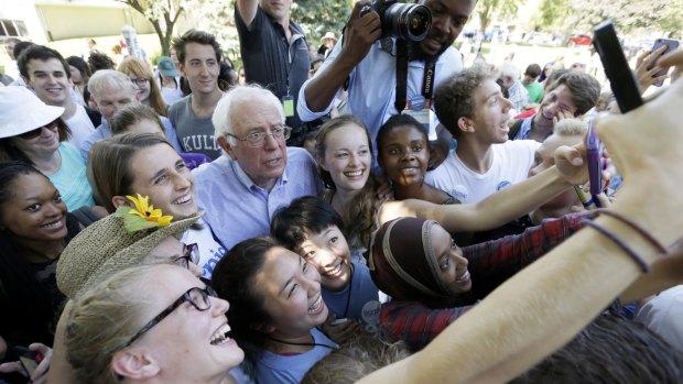 Democratic presidential candidate Bernie Sanders poses for a photo with supporters in Grinnell, Iowa.