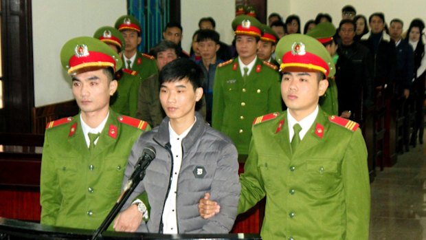 Blogger Nguyen Van Hoa, centre, stands on trial in Ha Tinhi, Vietnam, on Monday.