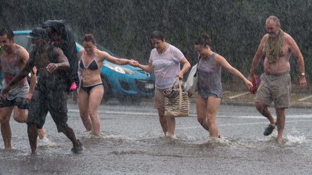 Brighton beach goers cross Brighton Rd as the wild weather hit Melbourne.