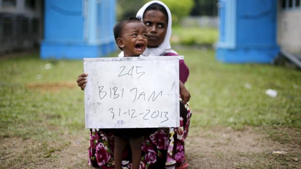 A Rohingya woman and her child pose for identification photographs in a temporary compound for refugees in Indonesia's Aceh Province in May.