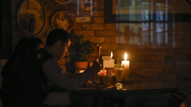 A man eats by candlelight in a cafe after a power failure, in Simferopol, Crimea, on Sunday.
