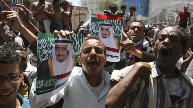 Demonstrators in support of the Saudi intervention hold posters of Saudi King Salman in the south-western city of Taiz on March 29.