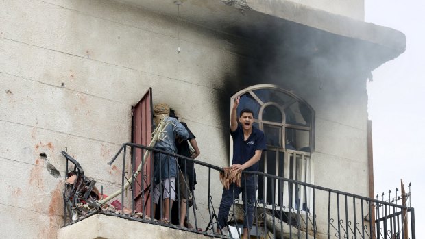 A man reacts at the site of an air strike in the Yemeni capital Sanaa on April 8.