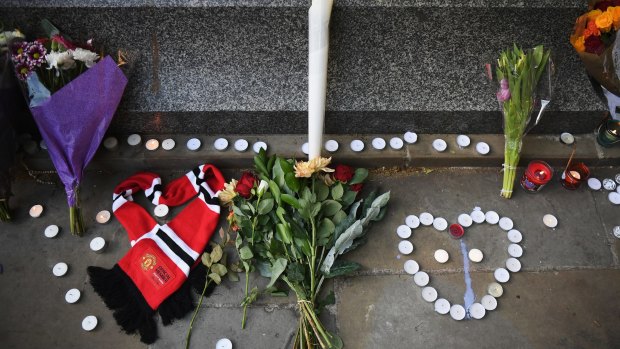 A Manchester United scarf, laid in the shape of a heart, lies next to flowers left by members of the public at a candlelit vigil to honour the victims of Monday evening's terror attack.