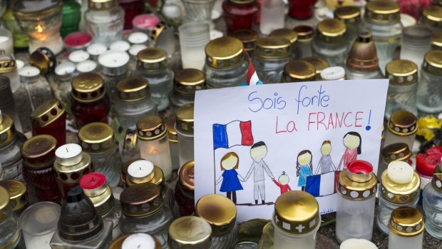 Candles and children's drawings outside the French embassy in Vilnius, Lithuania, for the victims of the Paris terror attacks.