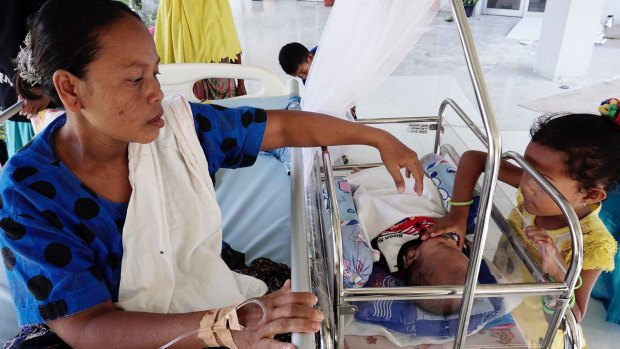 Wardiyah with her baby Ali Hafidul Ikram in the outside makeshift ward of Pidi Jaya hospital.