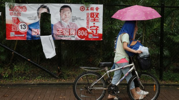 An election campaign banner for pro-Beijing election candidates Tang Ka-biu, left, and Wong Kwok-hing are seen defaced days before legislative elections, in Hong Kong. 